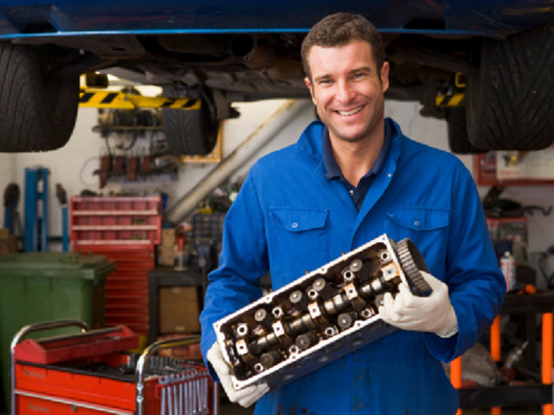 man smiling with car part in hand