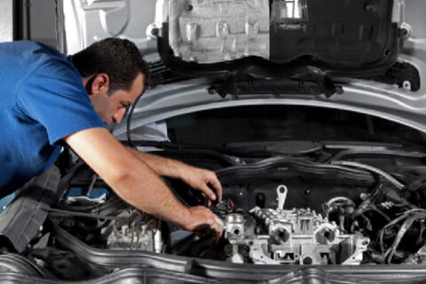 man repairng car engine