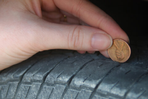 man placing coin over tyre