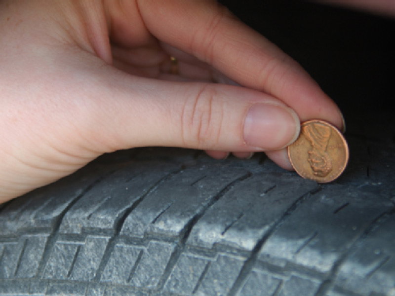 man placing coin over tyre