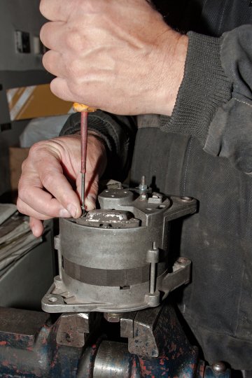 Man repairing engine with screw driver 