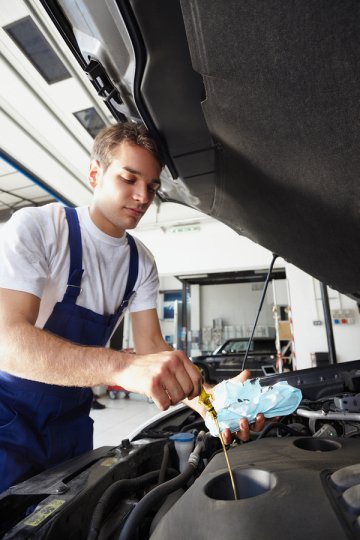 Man replacing the engine oil in car