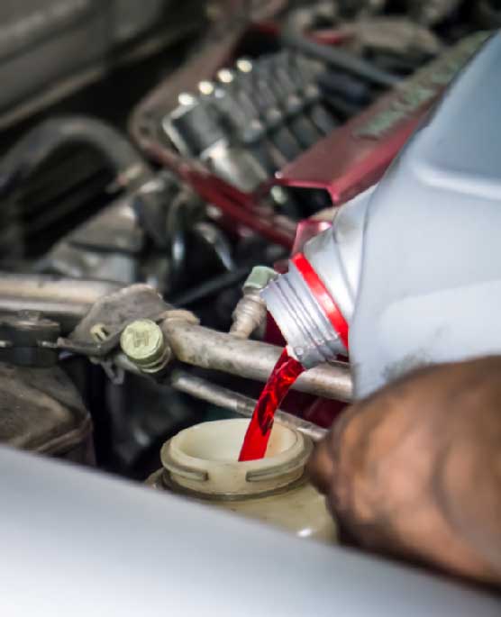 mechanic inserting engine oil in a car