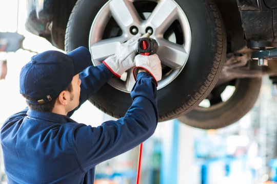 Man repairing the wheel cap of tyre